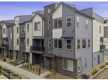 Modern townhome featuring a stylish multi-tone exterior and well-maintained landscaping at 12283 W 57Th Ln, Arvada, CO 80002