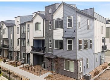 Modern townhouse exterior with gray siding, brick accents, and black trim details at 12283 W 57Th Ln, Arvada, CO 80002