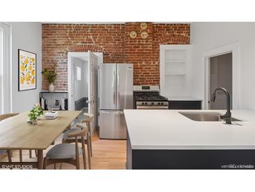 Charming kitchen with stainless steel appliances, a dining area, and exposed brick accents at 3817 Osage St, Denver, CO 80211