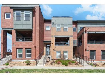 Modern townhome complex with brick and siding exteriors, balconies, and well-maintained landscaping on a sunny day at 5471 W 97Th Pl # E, Broomfield, CO 80020