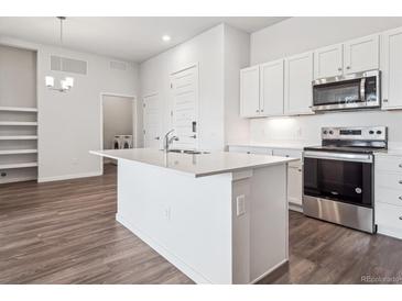 Modern kitchen with stainless steel appliances, island, and white cabinetry at 485 Interlocken Blvd # 101, Broomfield, CO 80021