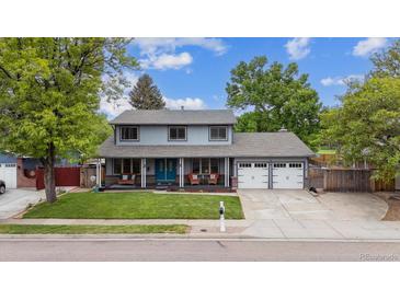 Charming two-story home with a well-maintained front yard and a welcoming covered porch at 8397 Chase Dr, Arvada, CO 80003