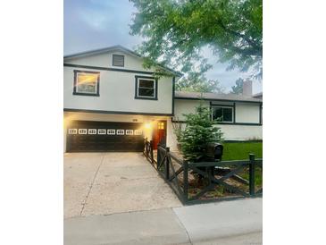 Charming two-story home with a black garage door and well-maintained front yard at 1676 S Fairplay St, Aurora, CO 80012