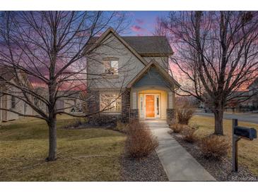 Charming two-story home with stone accents, inviting front porch, and manicured lawn at 1334 Carriage Dr, Longmont, CO 80501