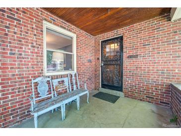 Inviting brick front porch with a bench and detailed front door at 3044 W 40Th Ave, Denver, CO 80211