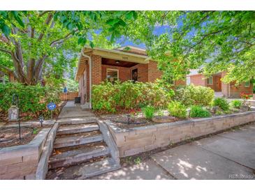 Charming brick home with a landscaped front yard and stone retaining wall at 3044 W 40Th Ave, Denver, CO 80211