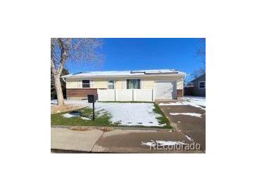 Ranch-style home with a large yard and attached garage at 5554 Crystal Way, Denver, CO 80239