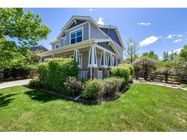 Inviting two-story home featuring manicured landscaping and a charming covered porch at 902 Jarvis Dr, Erie, CO 80516