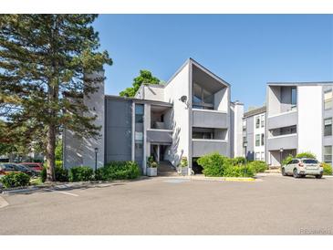 Exterior view of the condominium with well-maintained landscaping, parking, and gray and white facade at 6490 S Dayton St # L02, Englewood, CO 80111