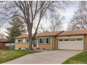 Charming ranch-style home featuring a two-car garage, and landscaped front yard at 12286 W Tennessee Ave, Lakewood, CO 80228
