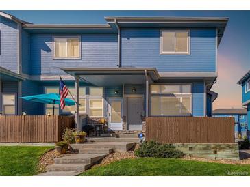 Charming two-story townhome with a covered porch and fenced yard at 12022 Locust St, Brighton, CO 80602