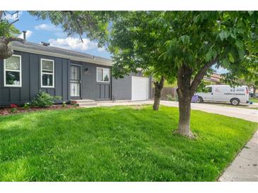 Charming single-story home featuring a well-manicured lawn, brick facade, attached garage and mature landscaping at 5170 Deephaven Ct, Denver, CO 80239