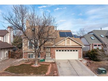 Charming two-story home features a brick-and-tan exterior, a two-car garage, and solar panels on the roof at 4334 Lisbon St, Denver, CO 80249