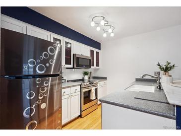 Modern kitchen features stainless steel appliances, white cabinetry, and sleek countertops at 14231 E Dickinson Dr # E, Aurora, CO 80014