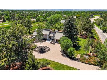 Stunning home with lush landscaping, circular brick driveway, and mature trees at 4 Greenridge Rd, Greenwood Village, CO 80111