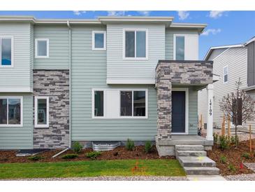 Stylish townhome featuring blue siding, stone accents, and a welcoming front porch entry at 14109 Deertrack Ln, Parker, CO 80134
