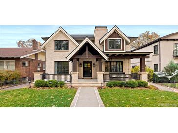 Beautiful two-story home boasting a manicured front yard, covered porch, and classic architectural details at 2218 S Clayton St, Denver, CO 80210