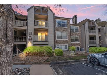 Condo exterior featuring stone accents, balconies, and manicured landscaping at 9222 E Arbor Cir # L, Englewood, CO 80111