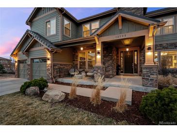 Inviting front porch with stone pillars and seating, offering a relaxing outdoor space at 10795 Sundial Rim Rd, Highlands Ranch, CO 80126