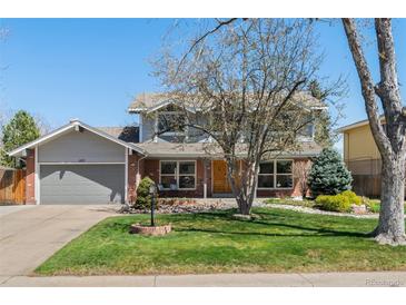 Charming two-story home with brick and siding, attached garage, and well-maintained lawn at 1430 S Lima St, Aurora, CO 80012