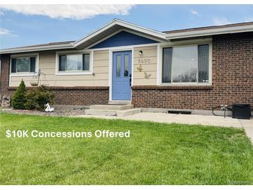 Charming single-story home with a brick facade, blue door, manicured lawn, and decorative butterfly accents at 5690 W 79Th Ave, Arvada, CO 80003