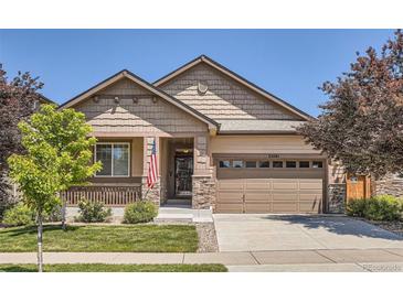 Inviting single-story home showcasing a well-manicured lawn, a two-car garage and attractive stone accents at 25561 E 5Th Pl, Aurora, CO 80018