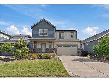 Charming two-story home with a well-manicured lawn, beautiful landscaping, and a two-car garage at 26789 E Cedar Ave, Aurora, CO 80018