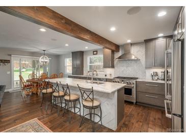 Modern kitchen featuring a large island, stainless steel appliances, and an open layout connecting to the dining area at 9325 Lark Sparrow Dr, Highlands Ranch, CO 80126