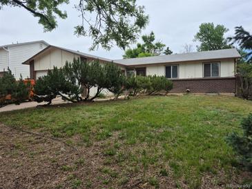 Charming single-story home featuring a lush lawn, mature trees and inviting curb appeal at 2832 S Mobile St, Aurora, CO 80013