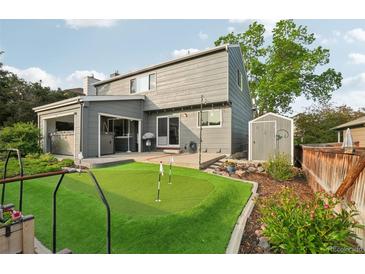 Captivating backyard with a putting green, patio, and shed, all beautifully framed by mature trees and meticulous landscaping at 6307 Monterey Pl, Highlands Ranch, CO 80130