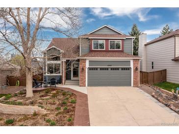 Charming two-story home with a landscaped front yard and attached two-car garage at 6307 Monterey Pl, Highlands Ranch, CO 80130