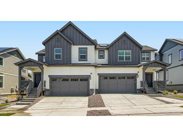 Modern townhome featuring attached garages and covered entrance at 577 Nightsky St, Erie, CO 80516
