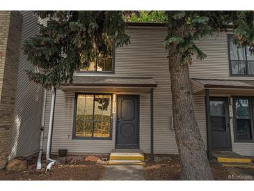 Inviting townhome with neutral siding and ample natural light streaming through large windows at 3550 S Harlan St # 105, Denver, CO 80235