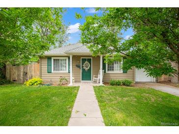 Charming home with a well-manicured front yard, walkway, and cozy rocking chair on the porch at 1221 Ulster St, Denver, CO 80220
