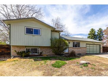 Split-level home featuring a two car garage, charming brick base and sunny sky above at 356 Aquarius Ct, Littleton, CO 80124