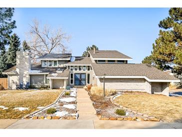 Charming home featuring a manicured front yard with rock landscaping, a brick chimney and walkway leading to the front door at 7747 S Forest Ct, Centennial, CO 80122