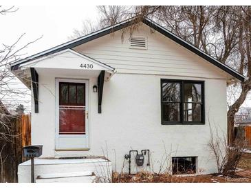 Charming single-story home featuring a white exterior, classic roofline, and inviting front entrance at 4430 S Cherokee St, Englewood, CO 80110