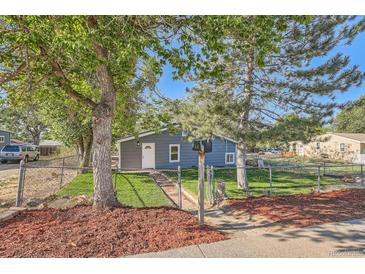 Charming home featuring a lush front yard, mature trees, and inviting curb appeal at 1764 W Atlantic Pl, Denver, CO 80223