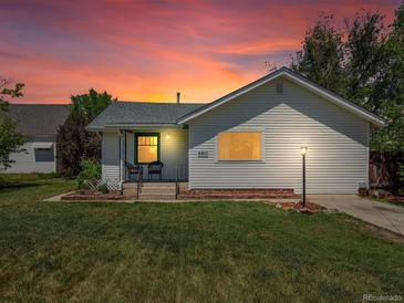 Charming single-story home with a well-maintained lawn and inviting front porch under a lovely sunset at 6801 W 52Nd Ave, Arvada, CO 80002
