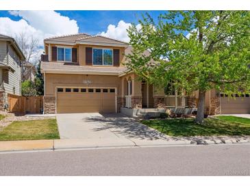 Charming two-story home featuring a covered front porch, two-car garage, and well-maintained front yard at 4763 Laurelglen Ln, Highlands Ranch, CO 80130