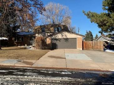 Charming two-story home featuring a spacious two-car garage and a driveway, complemented by a well-maintained front yard at 8727 E Girard Ave, Denver, CO 80231