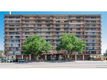 Multi-story condo building with multiple balconies and mature trees lining the front at 2225 Buchtel Blvd # 207, Denver, CO 80210