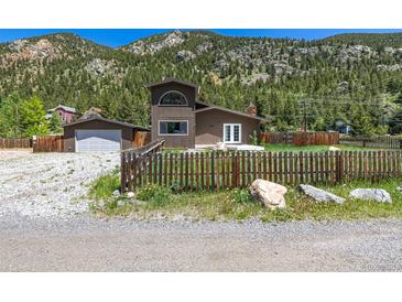 Charming exterior view of home with fenced yard and mountain views at 1500 Buckeye Cir, Georgetown, CO 80444