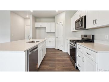 Bright kitchen with white cabinets, stainless steel appliances, and a large island at 2186 Flower Blossom Ave, Brighton, CO 80601