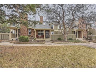 Charming townhouse featuring a brick facade and inviting front porch, complemented by a well-maintained lawn and mature trees at 7721 S Curtice Way # B, Littleton, CO 80120