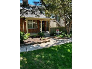 Charming brick home with a inviting front entrance and lush landscaping, featuring a 'For Sale' sign at 7721 S Curtice Way # B, Littleton, CO 80120