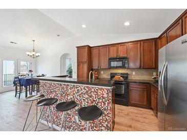 Stylish kitchen with stainless steel appliances, granite countertops, and a breakfast bar with seating at 7777 E 23Rd Ave # 203, Denver, CO 80238