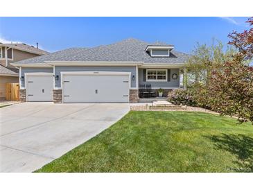 Charming single-Gathering home featuring a well-manicured lawn and a three-car garage at 16485 E 117Th Ave, Commerce City, CO 80022