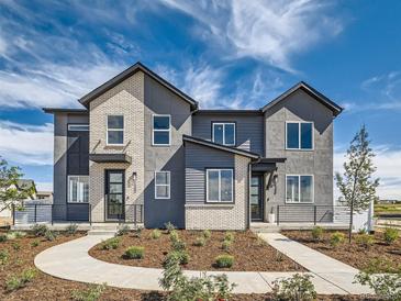 Modern townhome exterior with mixed materials, professional landscaping and inviting walkway at 1222 S Algonquian St, Aurora, CO 80018