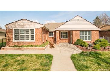 Charming brick home featuring a well-manicured lawn, inviting walkway, and pleasant curb appeal at 2972 Kearney St, Denver, CO 80207